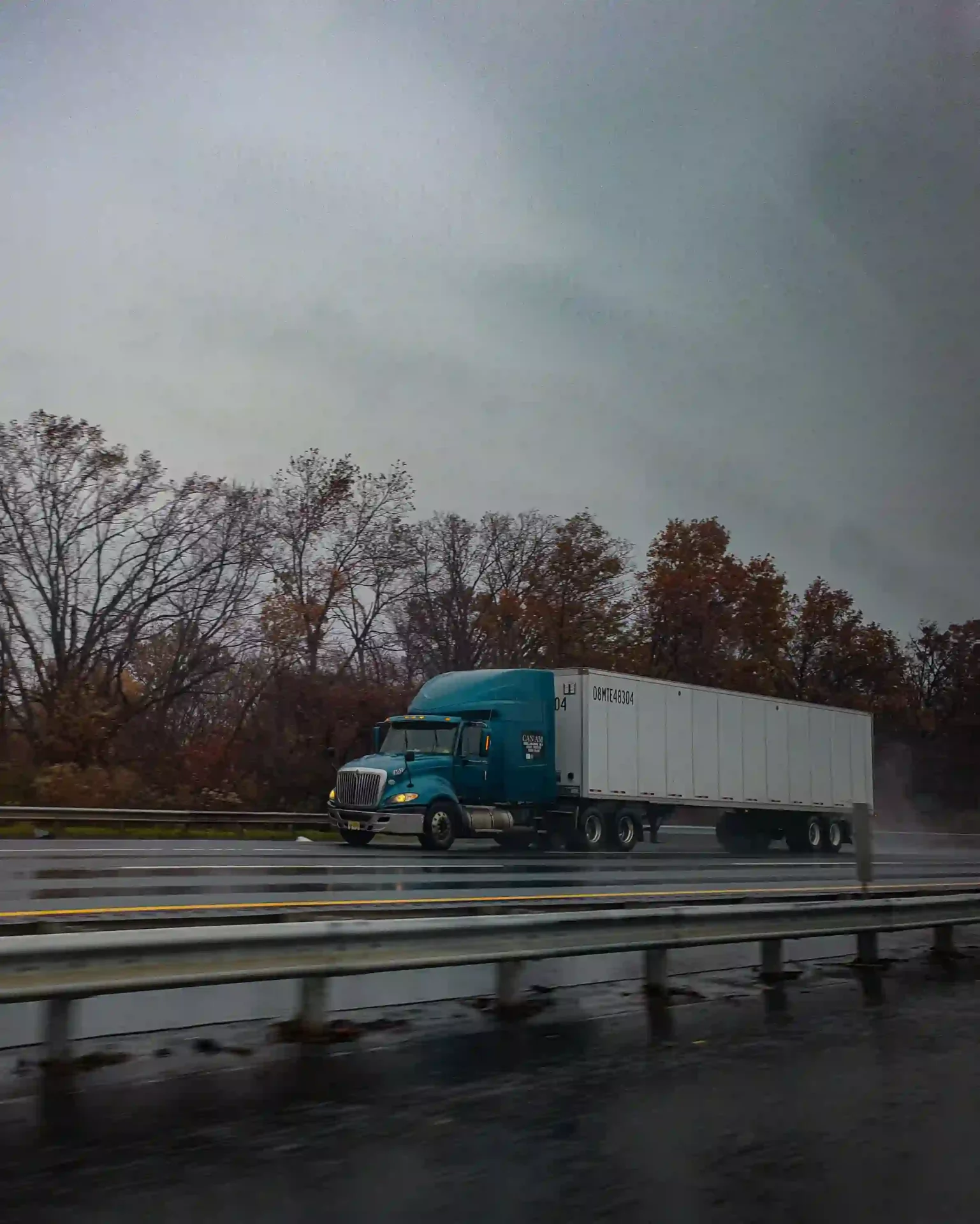 A delivery truck driving on a wet road