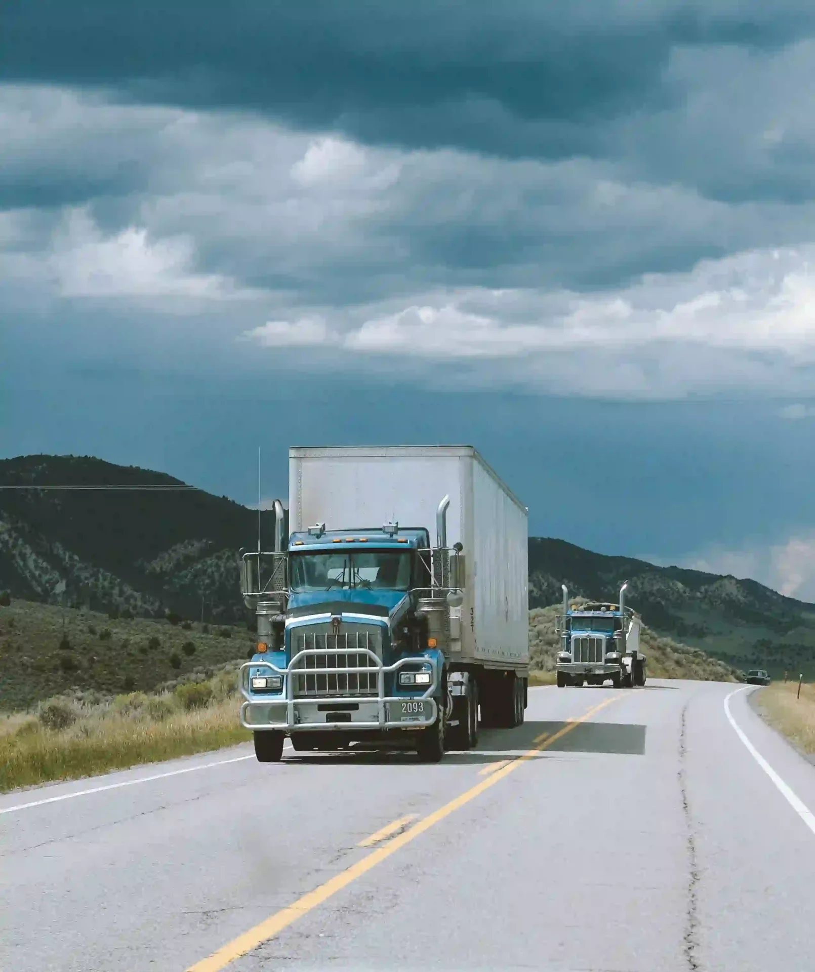 Two large delivery trucks on the road